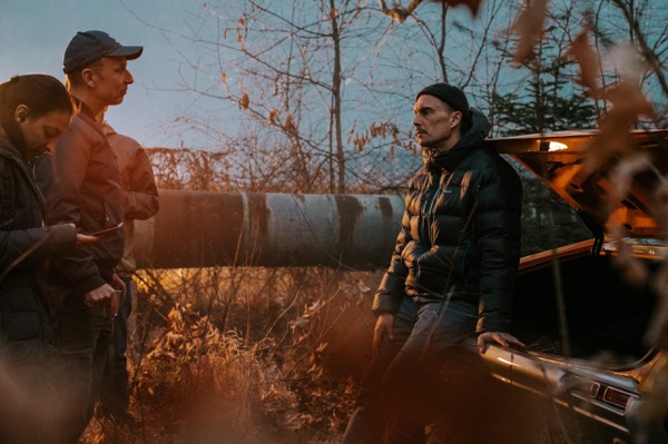 Crew with a camera in tall grass on an outdoor shoot