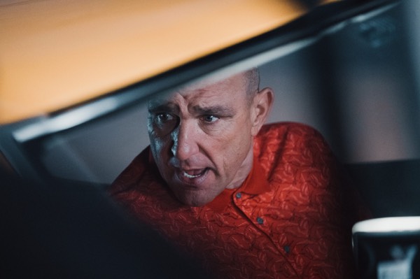 Actor in a car, filmed through the windscreen on set