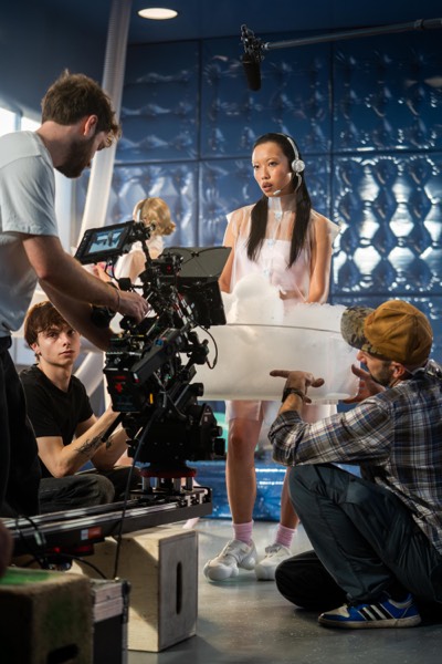 Camera operator filming actresses in white on a studio set