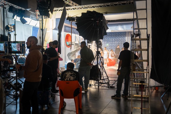 Crew and lighting in a large studio before a take