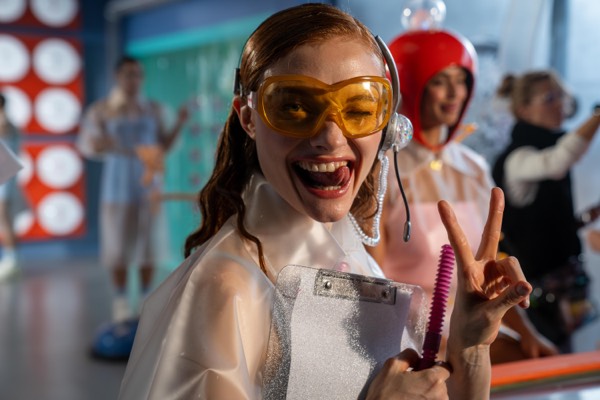 Smiling actress in yellow glasses on a colourful studio set