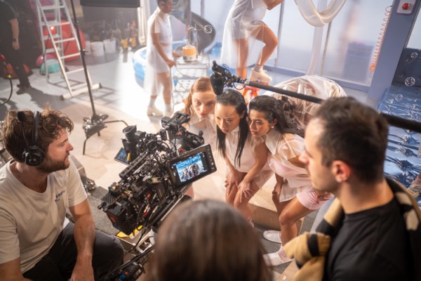The crew setting up a scene with a large cast in a studio
