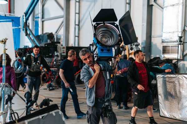 Lighting and crew around a water tank in a studio