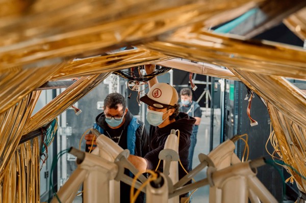 Crew on a golden set, seen through the structure