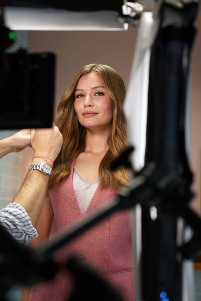 Actress in front of the camera in a studio for a beauty commercial