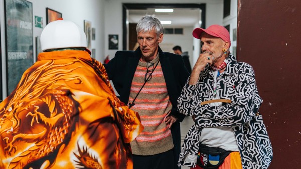 Actors in patterned costumes talking behind the scenes