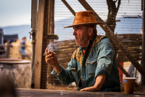 Actor in a cowboy hat on a wooden set