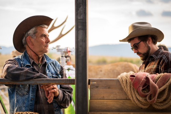 Two actors in cowboy hats behind the scenes of a western commercial