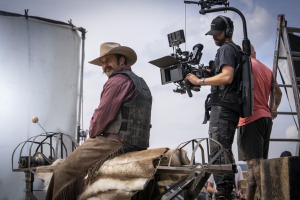 Camera operator filming a cowboy actor in a studio