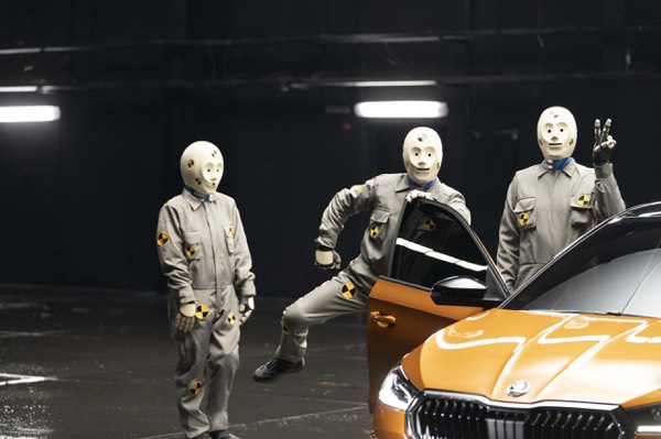 Actors in white suits around a car in a studio