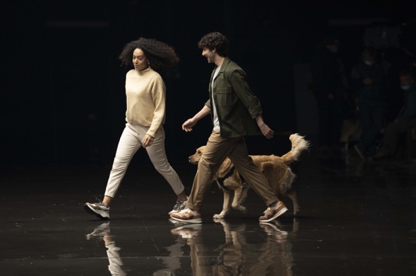 Actors walking with a dog in front of the camera in a studio