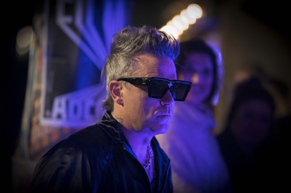 Performer in dark glasses under blue light