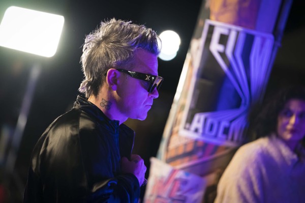 Performer in sunglasses behind the scenes of a music production