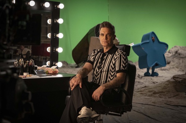Performer in a dressing room next to a green screen