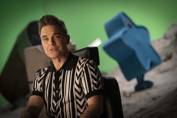 Performer in a striped shirt on a green-screen shoot