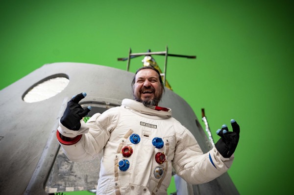 Actor in an astronaut suit in front of a green screen