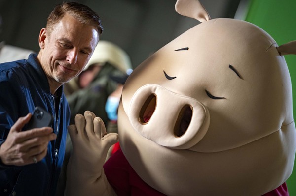 Actor with an animated pig character behind the scenes of a commercial