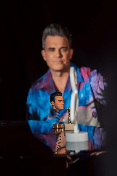 Portrait of a performer in a patterned shirt in a dark studio